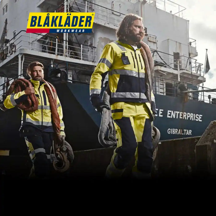 High-visibility safety workwear from Blaklader featuring yellow and navy reflective jackets and pants.